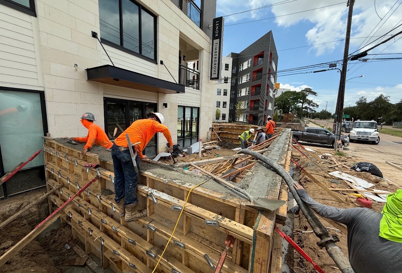 Workers placing concrete wall at multifamily project